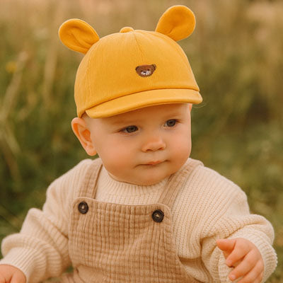 bébé porte sa casquette bebe jaune à oreilles
