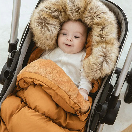 chanceliere bebe avec sa capuche qui protĂšge la tĂȘte de bĂ©bĂ© du froid
