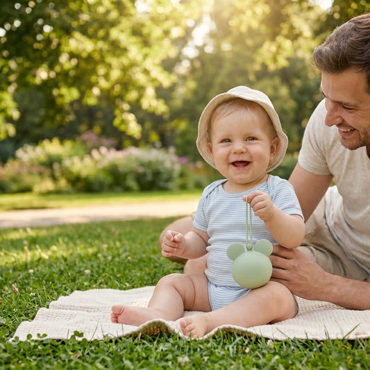 papa au parc avec bébé qui tient à la main sa boite à sucette