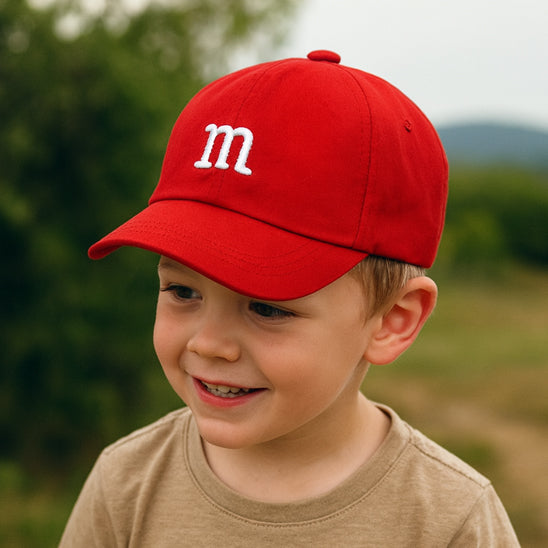 bébé porte sa casquette bebe rouge avec la lettre M
