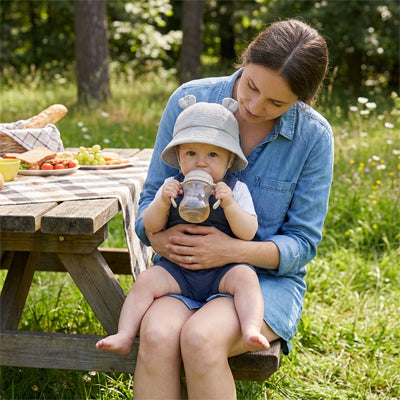 bébé avec maman au parc protégé du soleil par son chapeau bébé