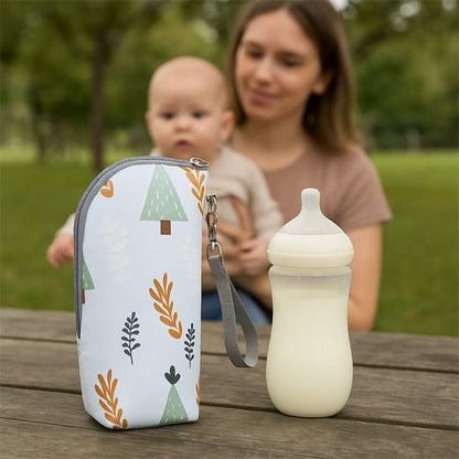 bébé regarde son biberon et son porte biberon isotherme