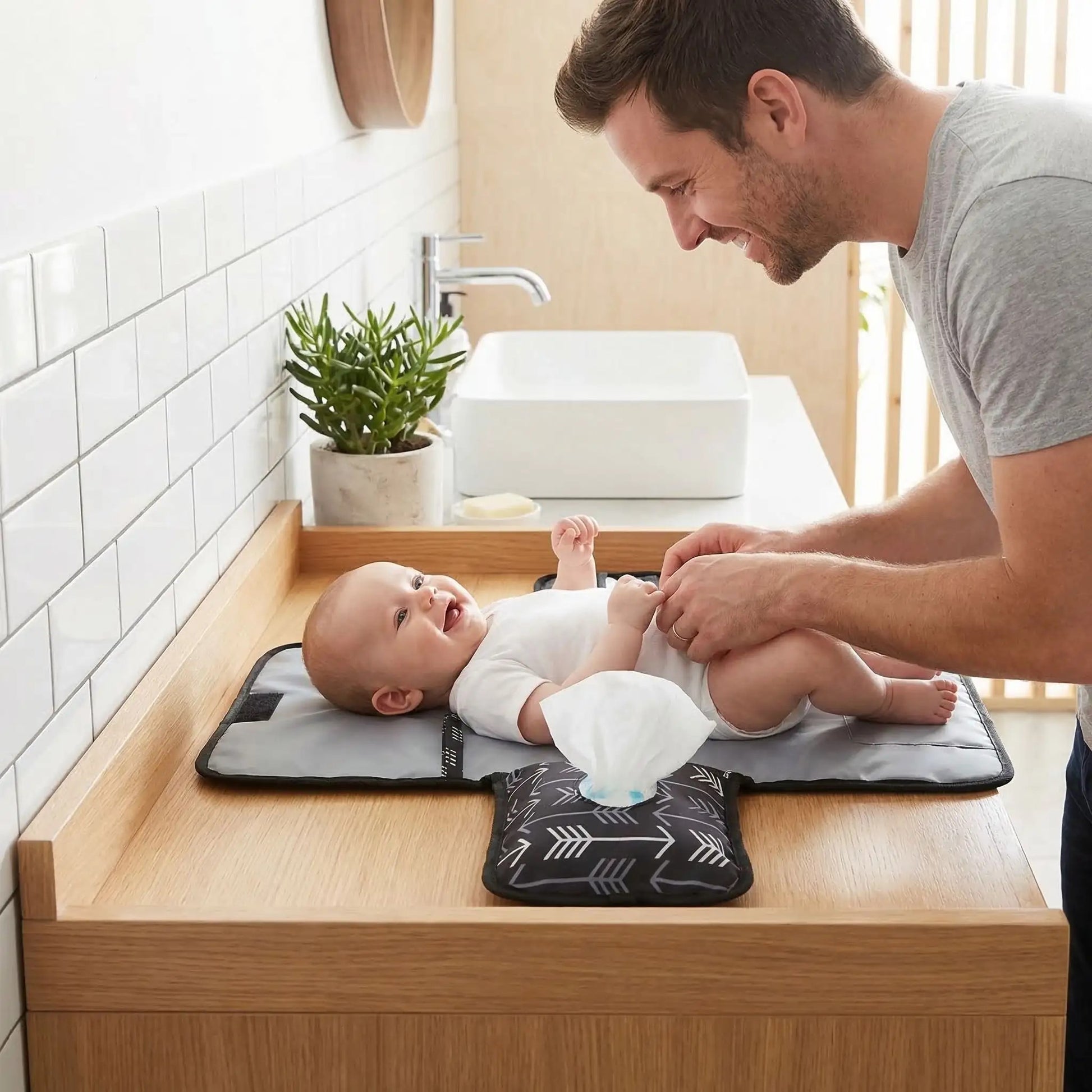 papa change bébé aux toilettes du restaurant sur son tapis pour changer bebe