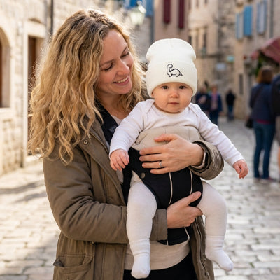 bébé dans les bras de maman avec son bonnet bebe chaud