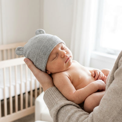 bébé edormi dans les bras de maman avec son bonnet bebe chaud