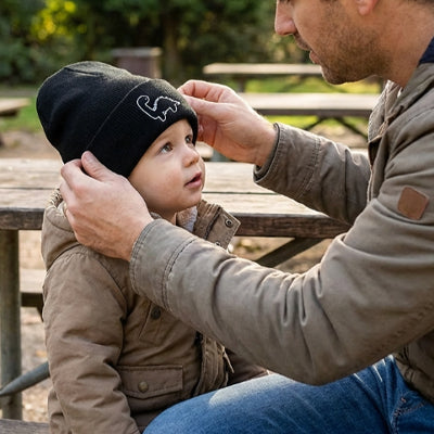 bébé au parc avec papa porte son bonnet bebe chaud noir