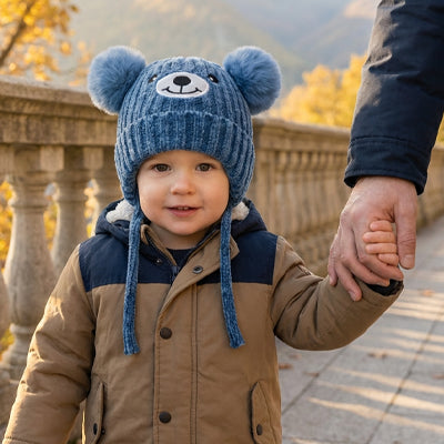 bébé se promène avec papa et porte son bonnet pour bebe bleu