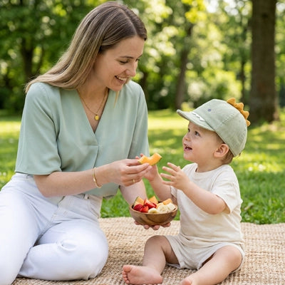 bébé au parc avec maman porte sa casquette bebe adorable verte