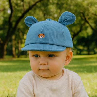 bébé au parc porte sa casquette bebe