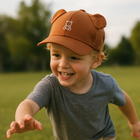Petit garçon joue au parc et porte sa casquette bebe marron
