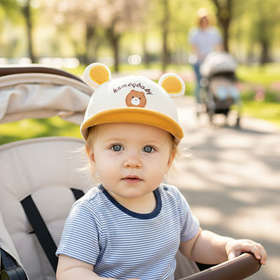 bébé porte sa jolie casquette bebe oreilles dans la poussette