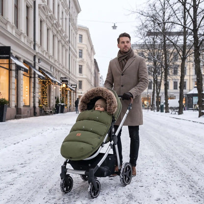 sortie sous la neige dans la chanceliere cosy dans sa poussette bien chaude