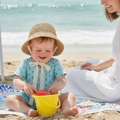 bébé qui porte son joli chapeau bebe à la plage