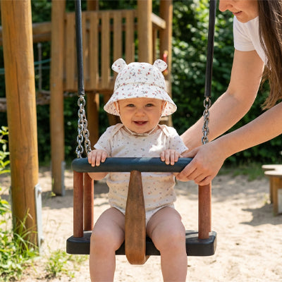 bébé porte son chapeau bébé au parc à jeux