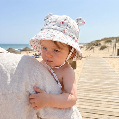 bébé porte son chapeau bébé à la plage