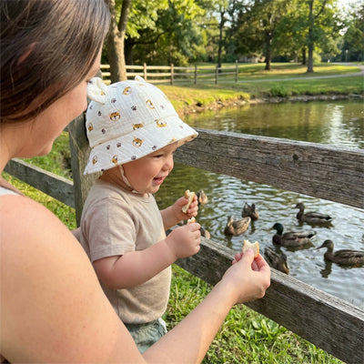 bébé porte son chapeau bébé au parc à canards