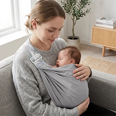 bébé blotti confortablement contre maman dans son echarpe de portage