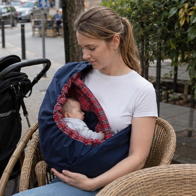maman assise porte son bébé endormi confortablement dans son echarpe de portage