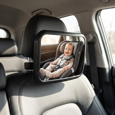 bébé en train de sourire et regarde maman dans son miroir pour voiture bébé