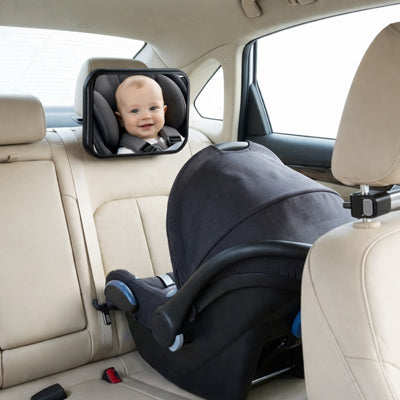 bébé en train de sourire et regarde maman dans son miroir pour voiture bébé