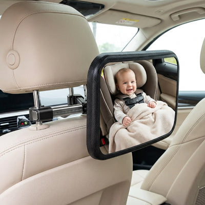 bébé en train de sourire et regarde maman dans son miroir pour voiture bébé