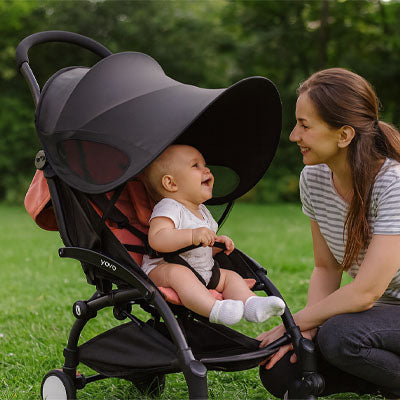 bébé bien protégé avec son pare soleil poussette