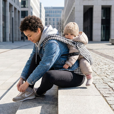 maman porte bébé sur le dos dans son porte bébé physiologique 