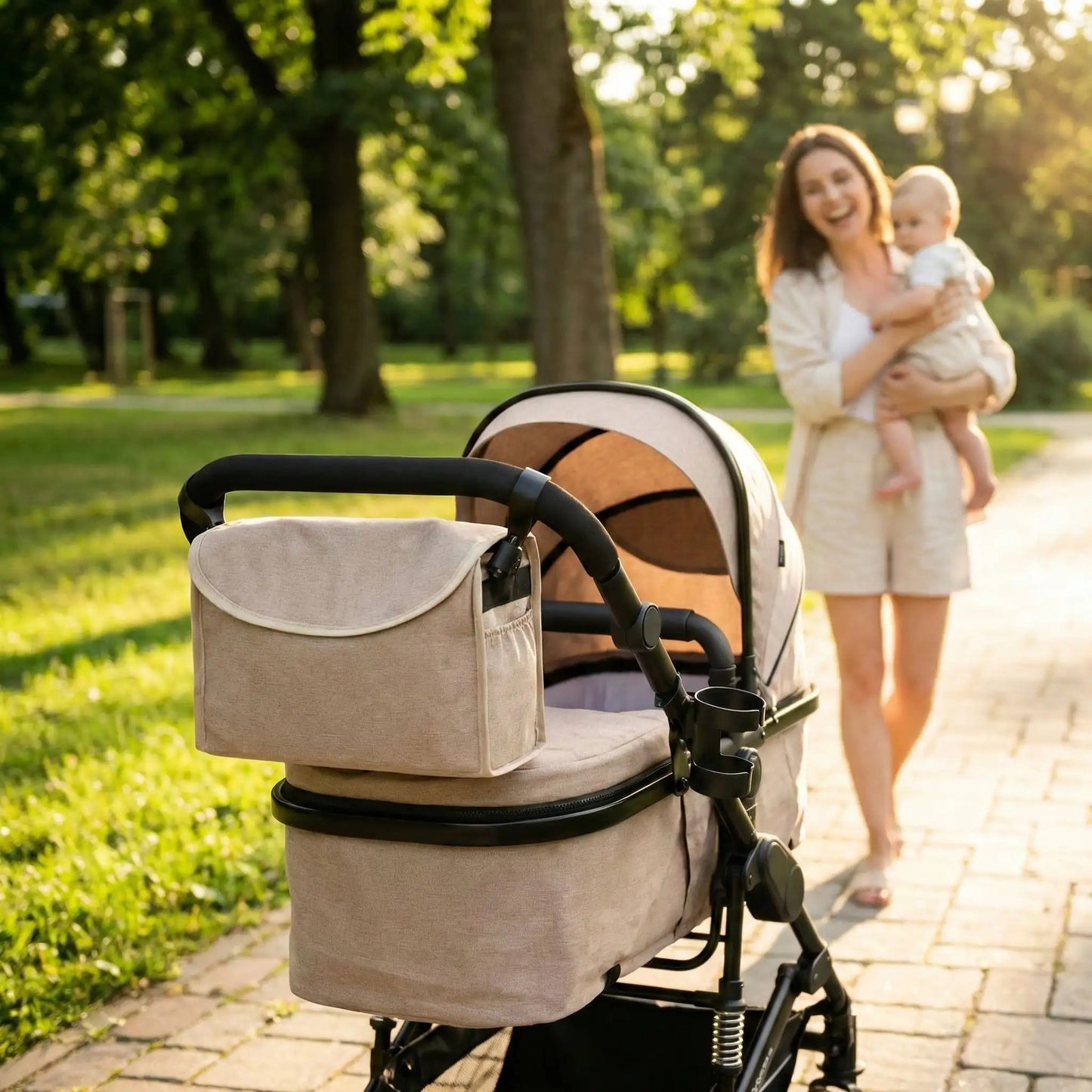 maman porte bébé devant sa poussette 3 en 1 et le joli sac assorti