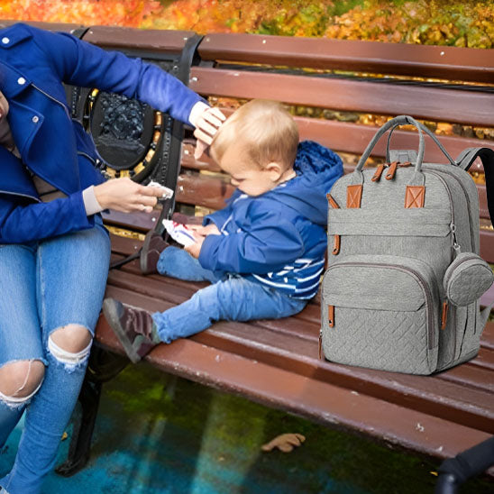 maman au parc avec bébé et le sac à dos à langer