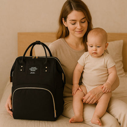 maman porte bébé sur ses genoux et le sac à dos à langer posé à coté