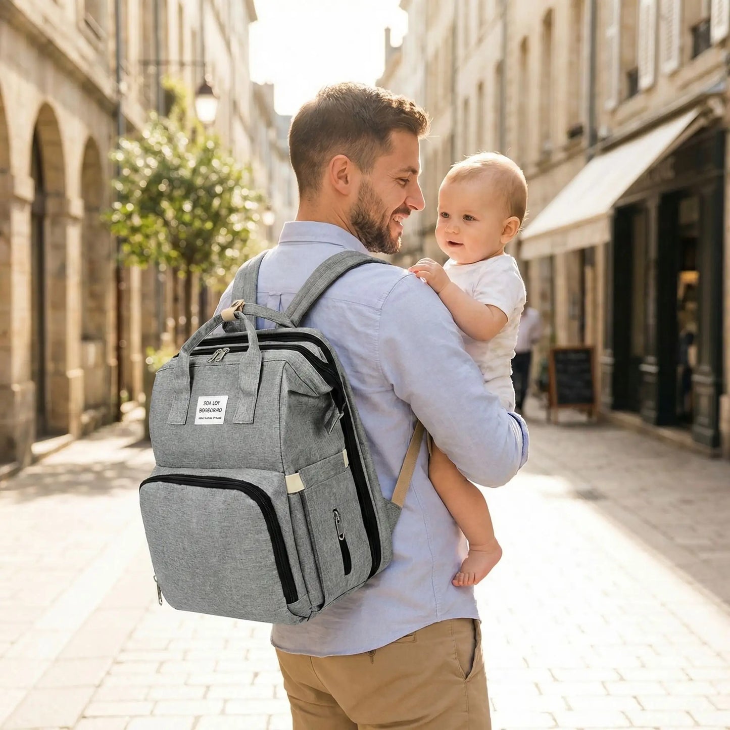 papa se promène avec bébé et porte son sac à dos à langer