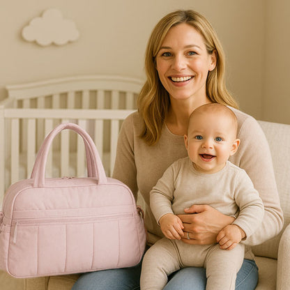 sac a langer bebe et bébé qui sourit dans les bras de maman