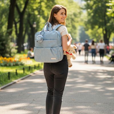 maman porte le sac a langer bebe au parc