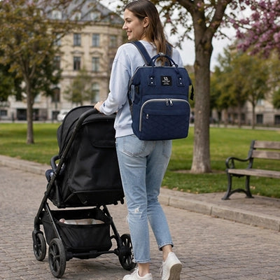 maman porte le sac a langer sur son dos et bébé dans sa poussette