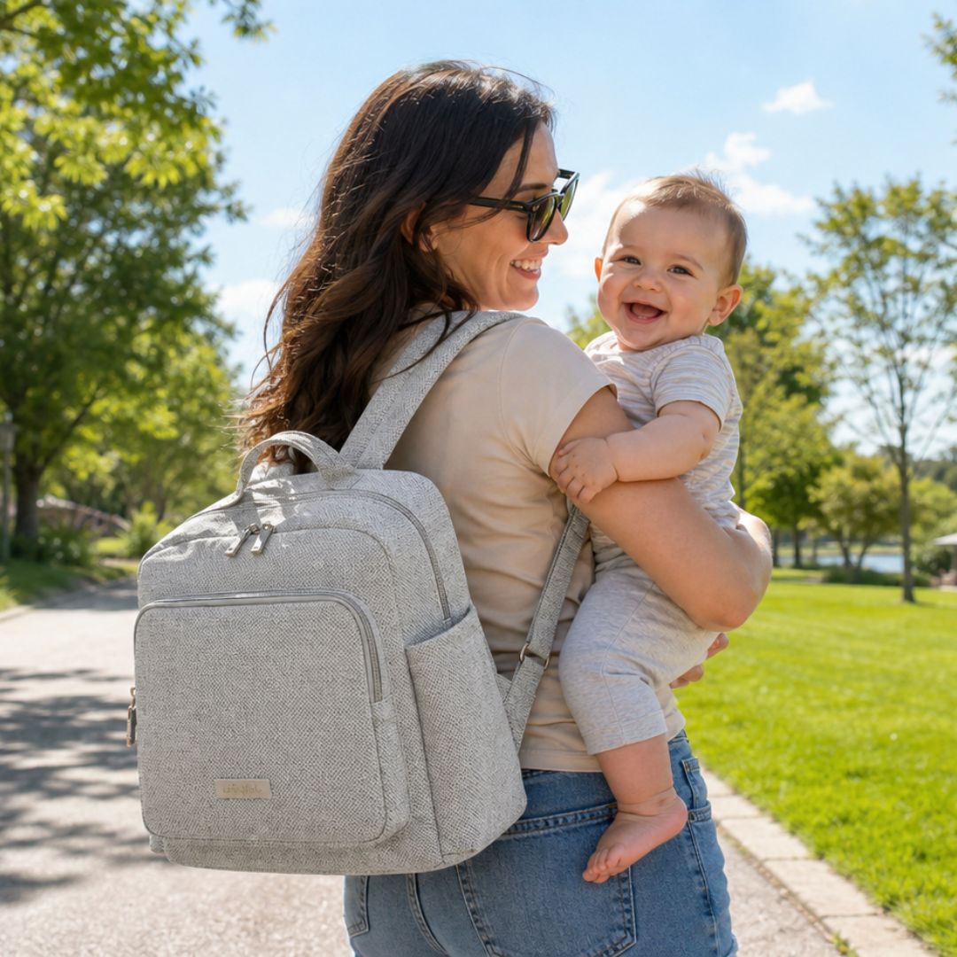 maman porte son sac a langer gris et se promène au parc