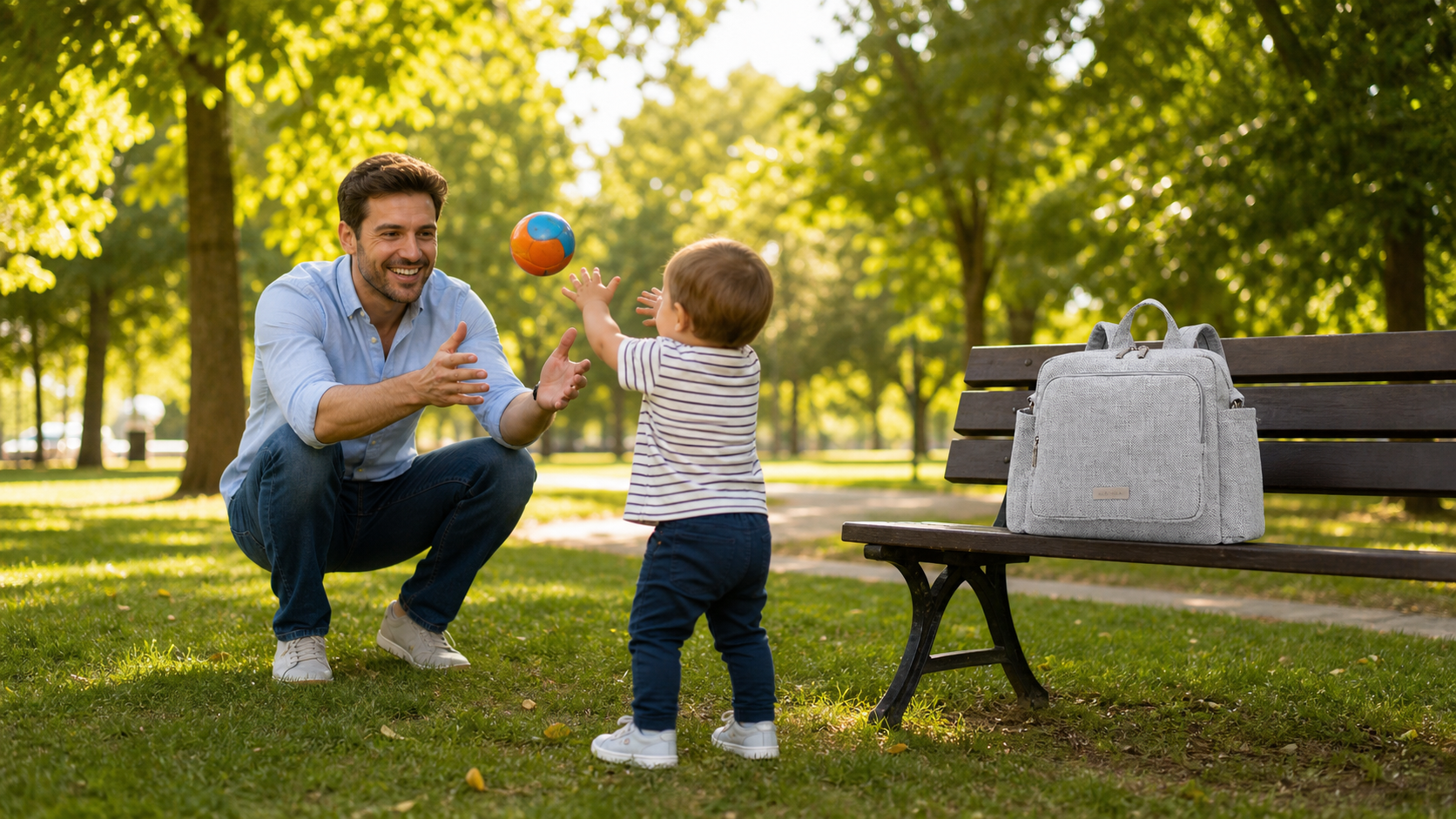 papa avec bébé au parc, le sac a langer gris osé sur le banc
