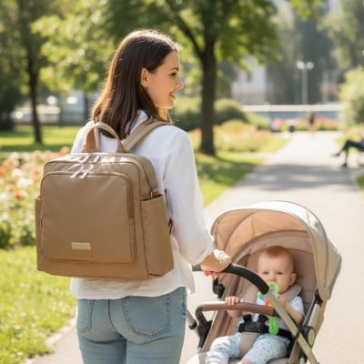 maman pousse la poussette de bébé et porte son sac à langer